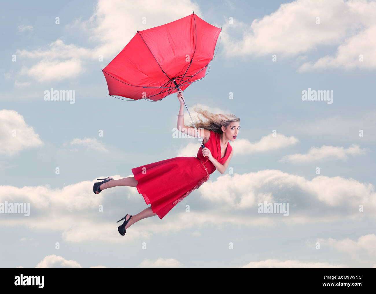 Attraktive Frau, die in den blauen Himmel fliegen Stockfoto