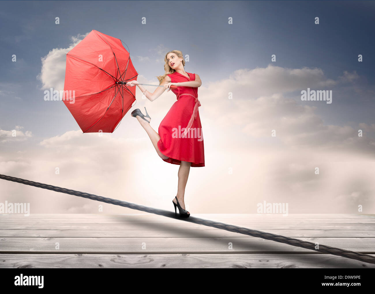 Hübsche Frau mit einem gebrochenen Schirm über den Wolken Stockfoto