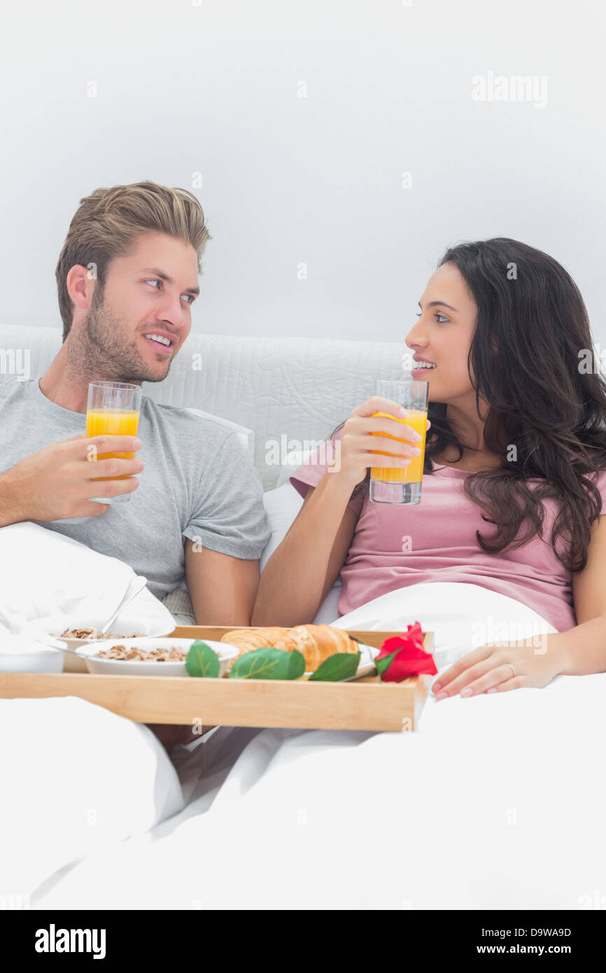 Fröhliches paar mit Frühstück im Bett Stockfoto