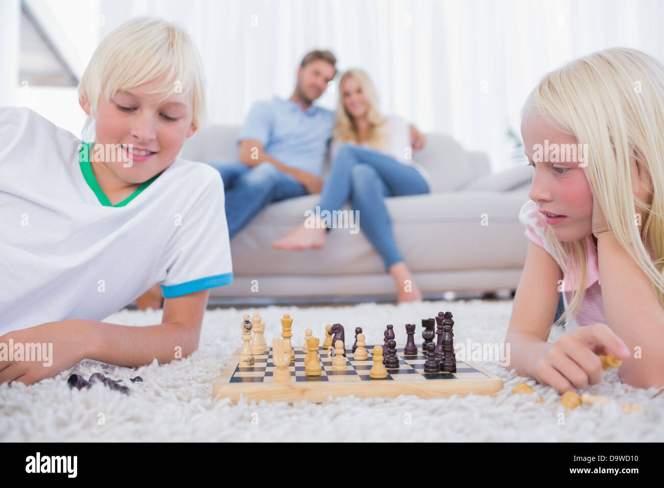Kinder spielen Schach im Wohnzimmer Stockfoto