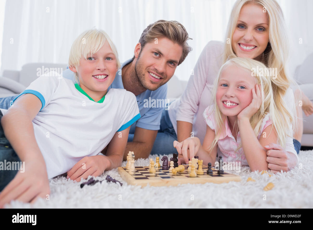 Lächelnde Familie zusammen spielen Schach Stockfoto