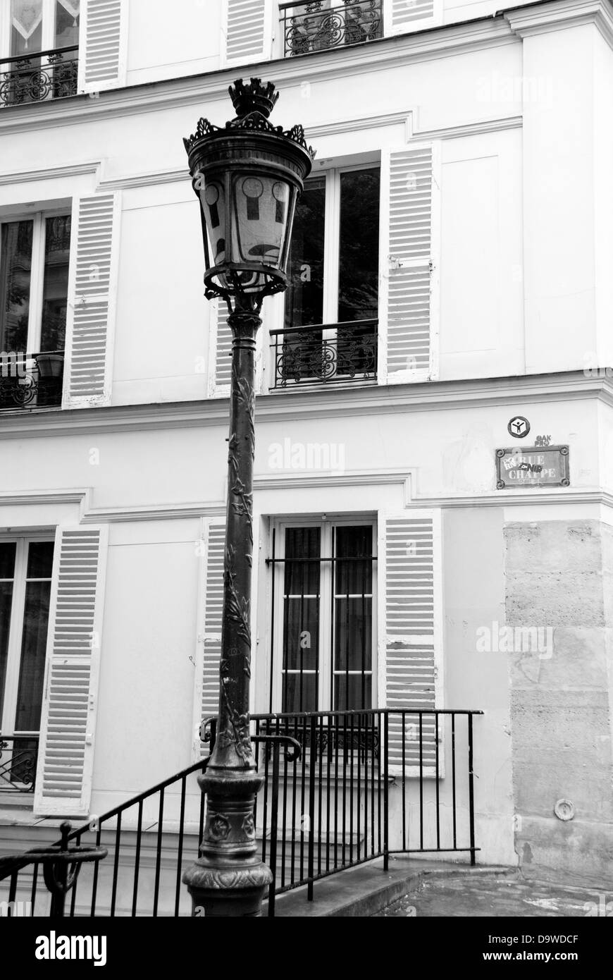 Haus und Laternenpfahl in Montmartre, Paris. Die Lampe wurde ein Gesicht gemalt. Stockfoto