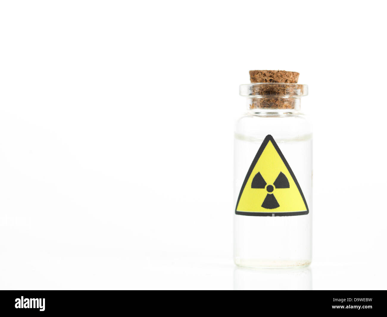 weißen Hintergrund mit eine kleine transparente Glasflasche mit einem braunen Korken und ein Warnschild Radioaktivität Stockfoto