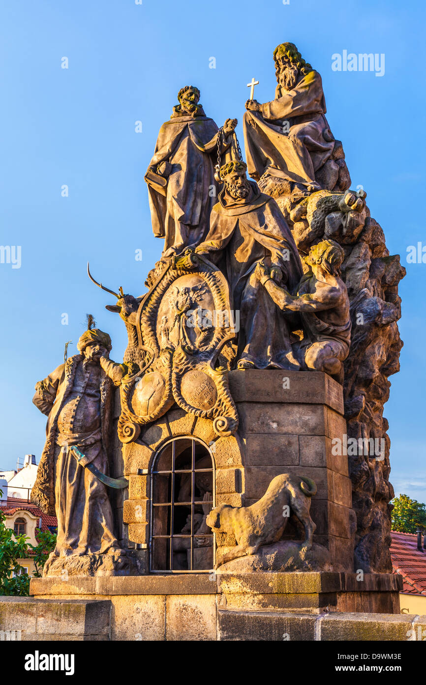 Statuen von Heiligen John von Matha, Felix von Valois und Ivan auf der Karlsbrücke, Prag in der frühen Morgensonne. Stockfoto