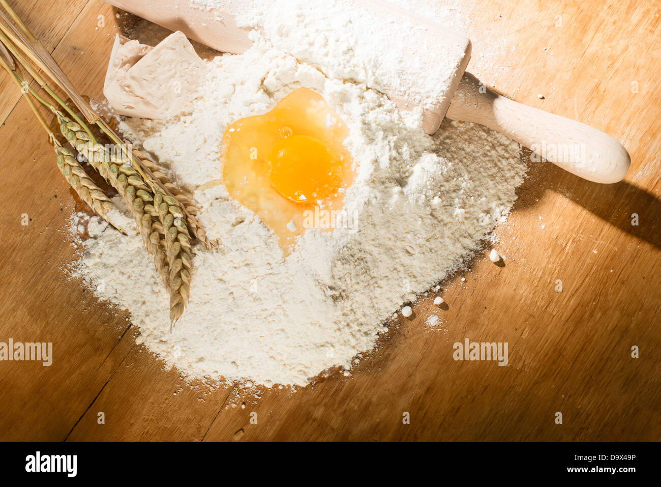 Haufen von Mehl, Nudelholz und Weizen. Ei auf Mehl Stockfoto