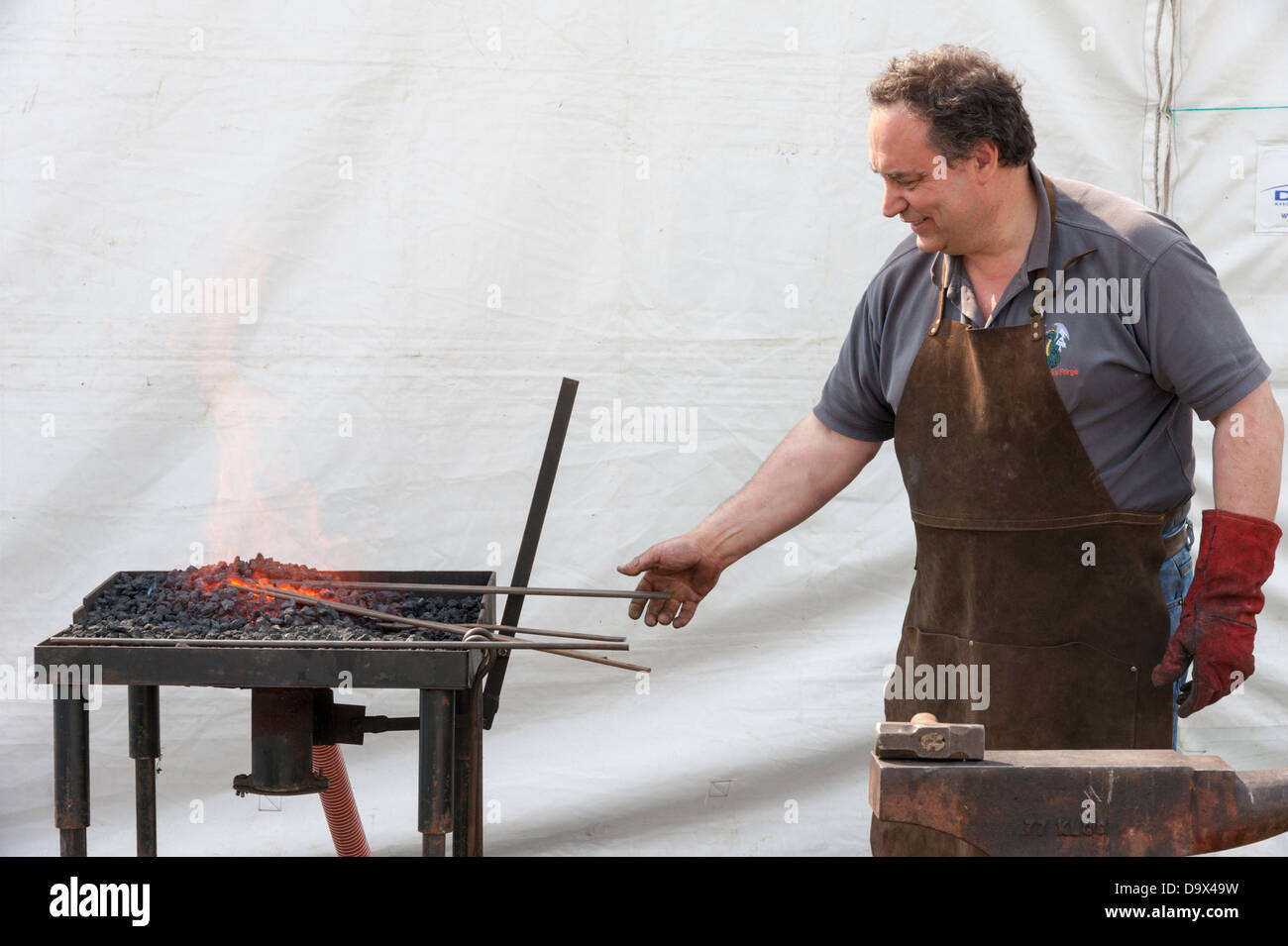 Ein Schmied Heizung rote Roheisen bei einem Feuer während eines Wettkampfes an der Royal Cornwall Show 2013 Stockfoto