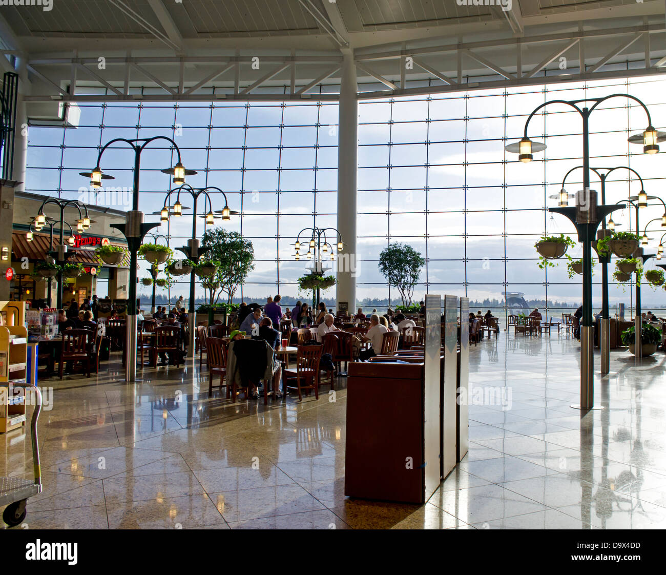 Eines der Lebensmittel und Einkaufsvierteln von Seattle Sea-Tac Flughafen.  Ein attraktives Gebiet mit Pflanzer, Tabellen und viel Licht. Stockfoto