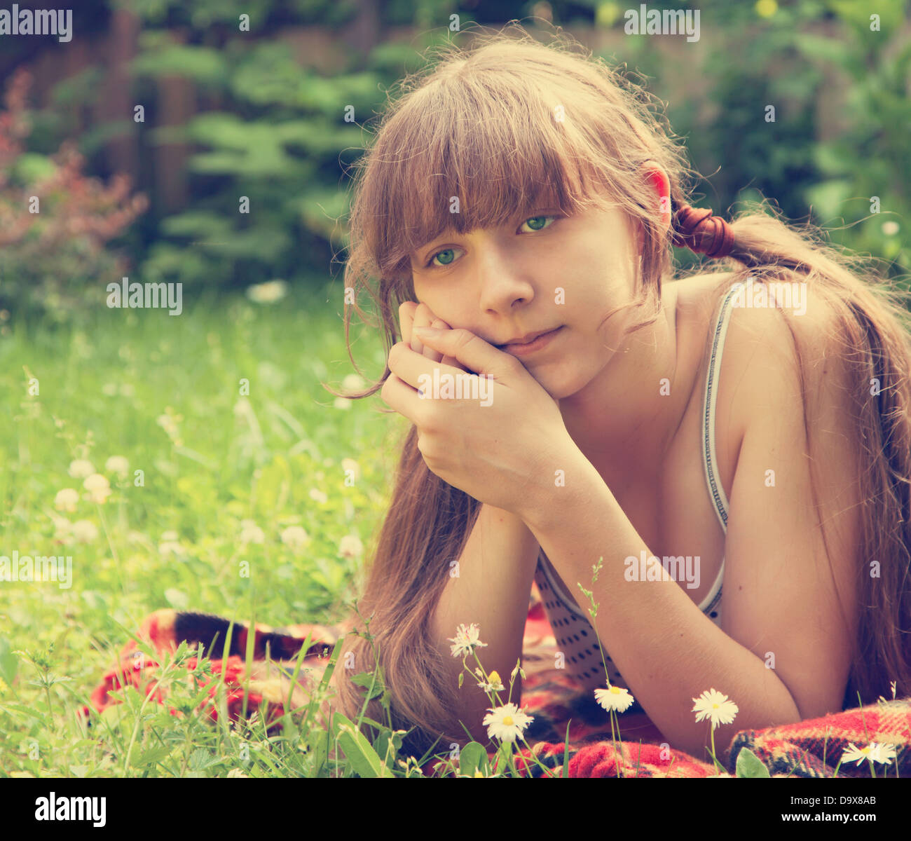 Schöne junge Mädchen liegend auf dem grünen Rasen im Freien. Sommer. Stockfoto