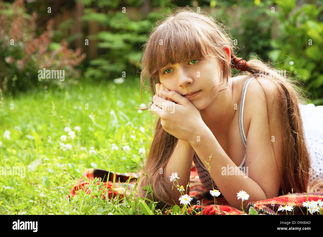 Schöne junge Mädchen liegend auf dem grünen Rasen im Freien. Sommer. Stockfoto