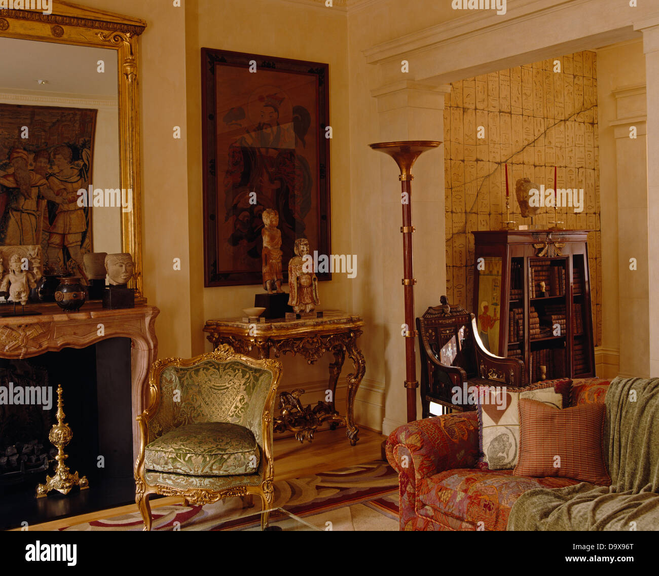 Vergoldete Polsterstuhl neben Kamin im großen Salon mit vergoldeten Konsolentisch unter großen Gemälde Stockfoto