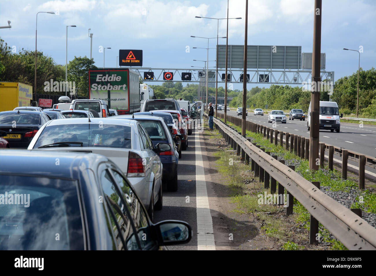 Menschen kommen aus ihren Autos im Stau auf der Autobahn m6 in der Nähe von Birmingham Stockfoto