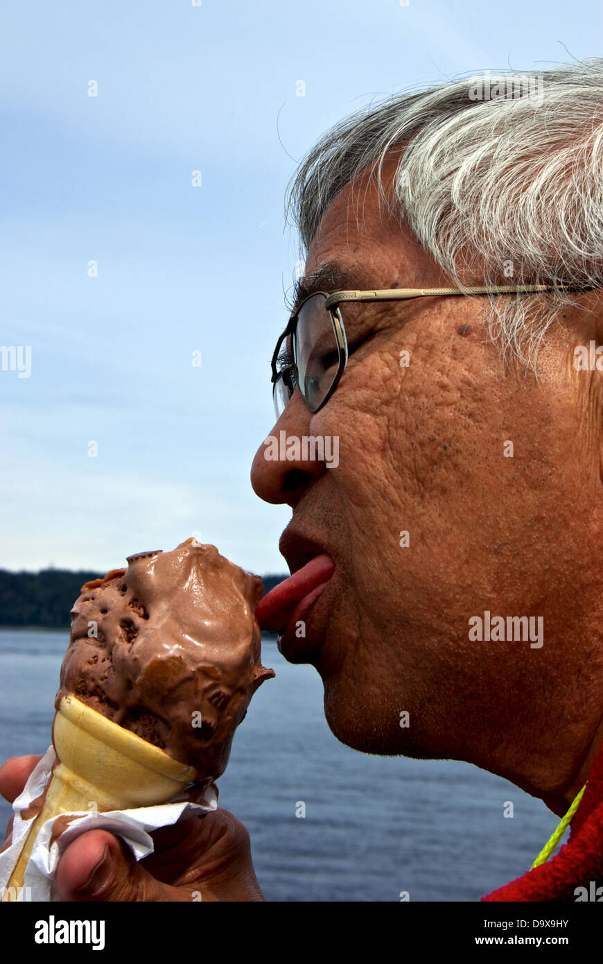 Chinesischer Mann Essen 'Baby' Größe Schokolade Erdnussbutter Klumpen Eis Kegel Entdeckung Fishing Pier Essen Getränkestand Stockfoto