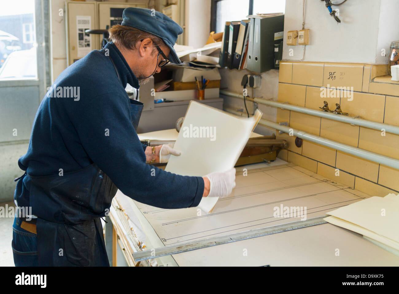 Deutschland, Bayern, reifer Mann mit Büttenrand Papier in Druckerei Stockfoto
