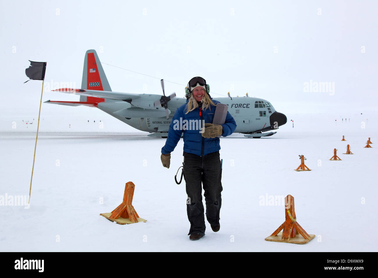 Weibliche Landebahn Crew Arbeiter und C130 Hercules Flugzeug am Südpol, Antarktis Stockfoto