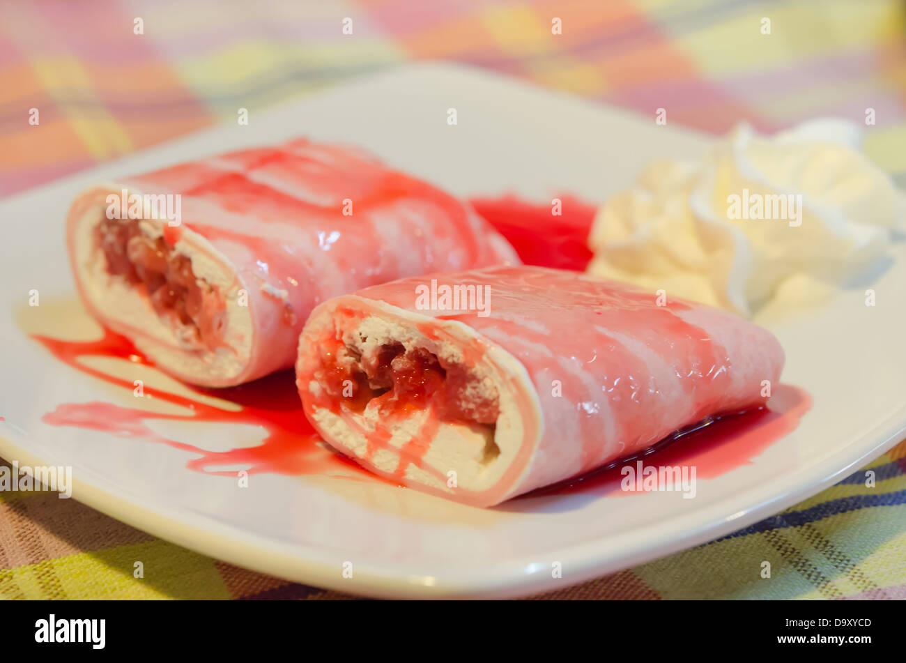 Close-up-Krepp Brötchen gefüllt mit weißen Sahne und Erdbeeren, mit Erdbeer-Sirup Stockfoto