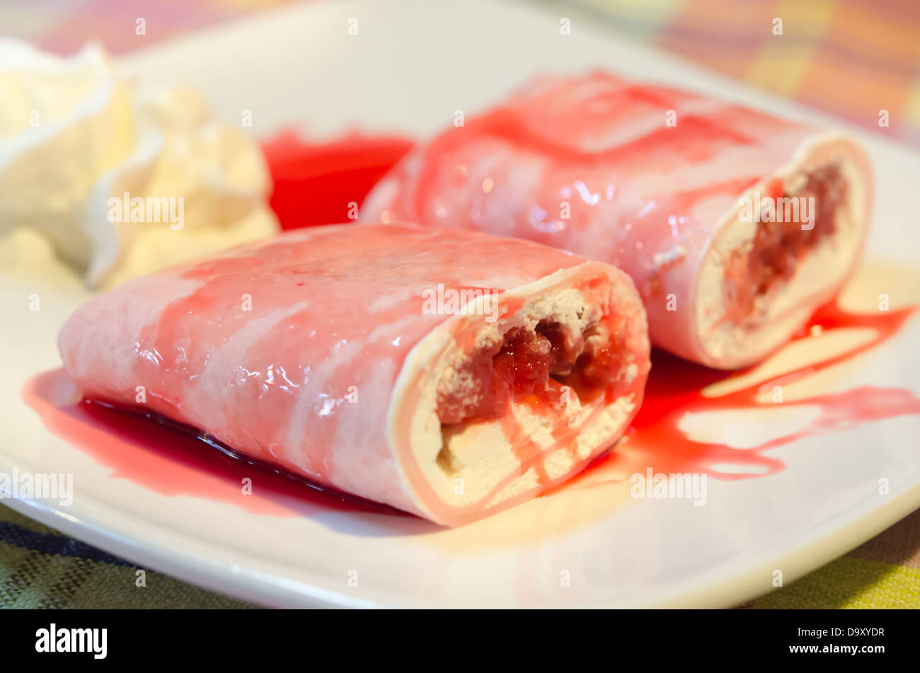 Krepp Brötchen gefüllt mit weißen Sahne und Erdbeeren, mit Erdbeer-Sirup Stockfoto
