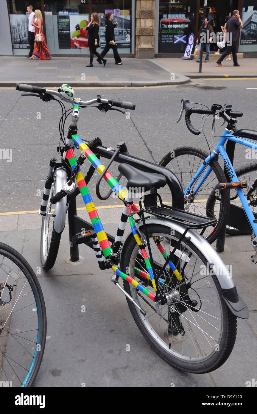 Farbige Fahrräder gesichert an einem Fahrradständer Stockfoto