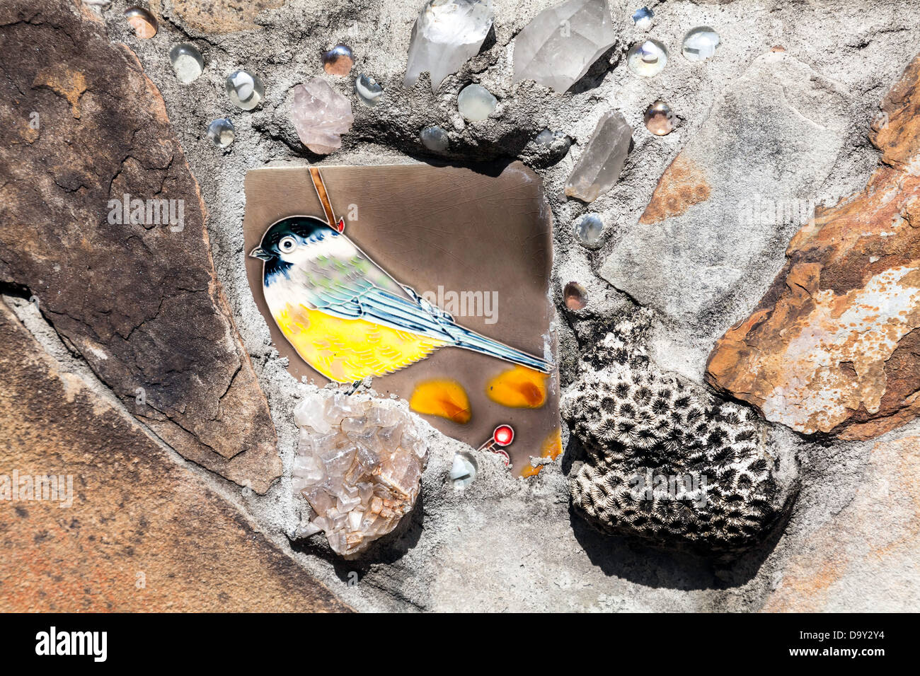 Bildhauerkunst, keramische Fliesen und einem kleinen Korallen Felsen eingebettet in Steinmauer, die die Kanapaha Gärten Kinder Garten umgeben. Stockfoto