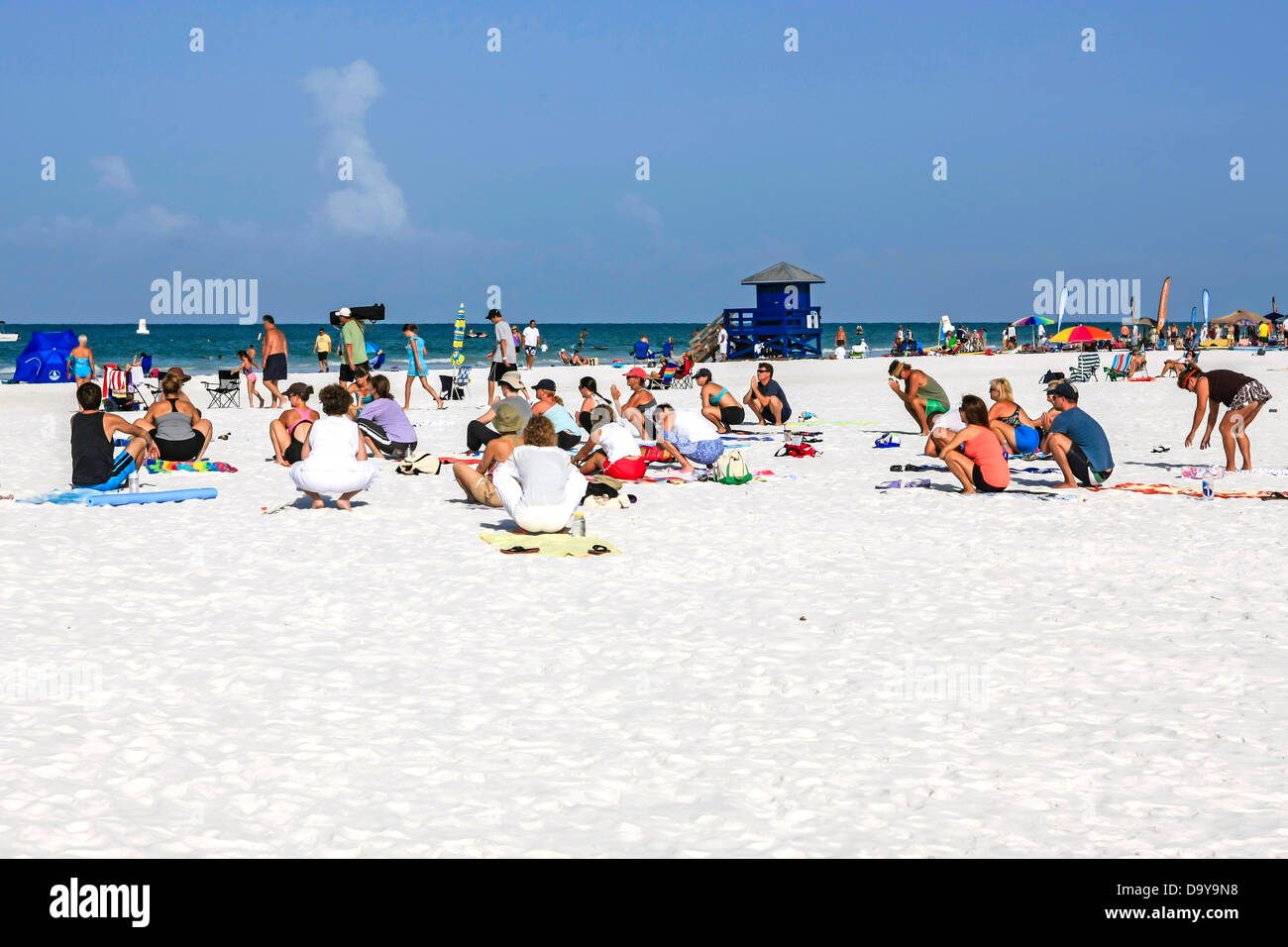 Menschen beteiligen sich an den frühen Vormittag zur freien Verfügung-Yoga am Siesta Key Beach in Florida Stockfoto