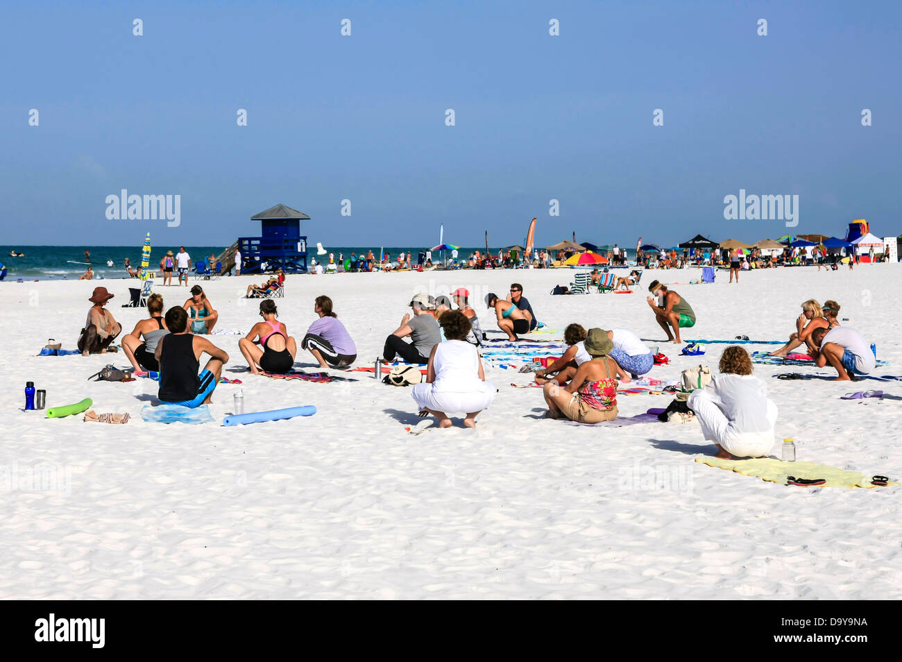 Menschen beteiligen sich an den frühen Vormittag zur freien Verfügung-Yoga am Siesta Key Beach in Florida Stockfoto