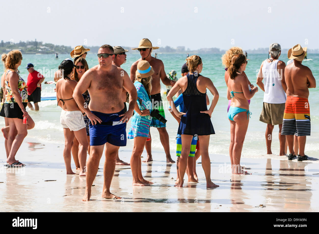 Zuschauer beobachten die Stand Up Paddlerboard Wettbewerber auf Siesta Key Beach FL Stockfoto