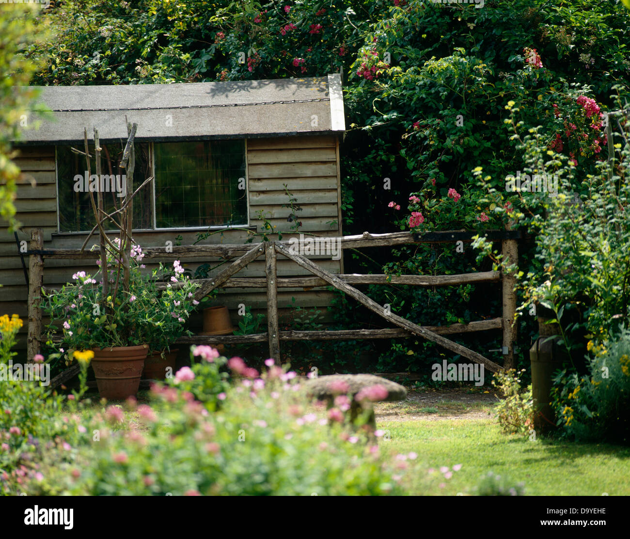 Bauerngarten mit hölzernen Gartenhaus über fünf Balken Holztor Stockfoto