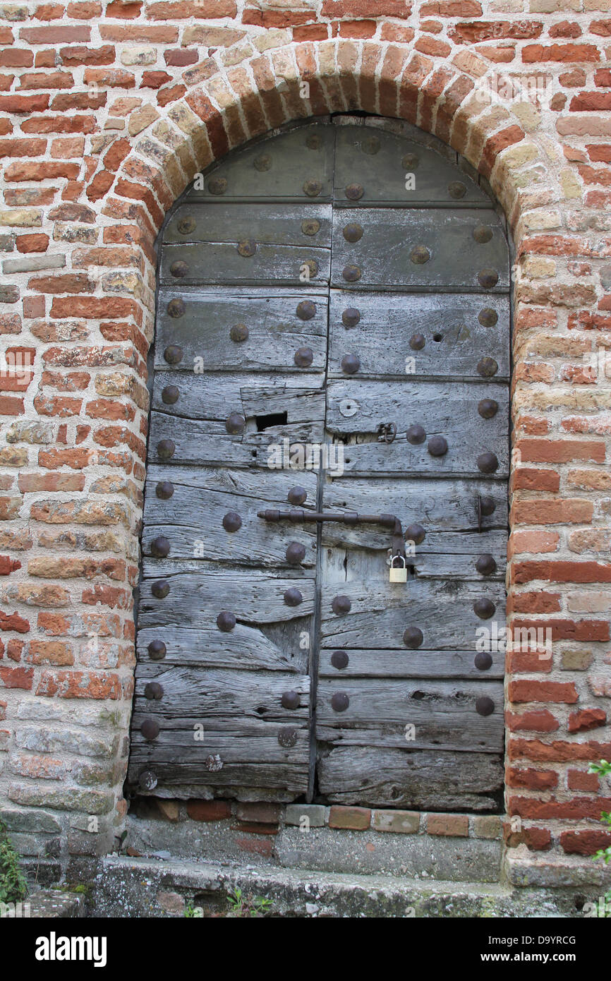 Sehr altes Eisen beschlagene Holztür in historischen Mauern der alten Stadt Amandola, Le Marche, Italien Stockfoto