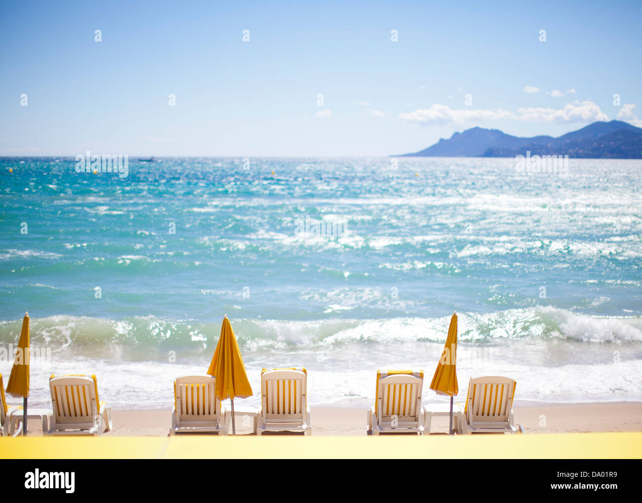Reihe von gelben Sonnenschirme und liegen am Mittelmeer. Stockfoto