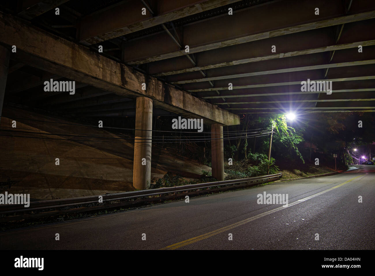 Einsamen Straßenlaterne unter Autobahnbrücke bei Nacht Stockfoto