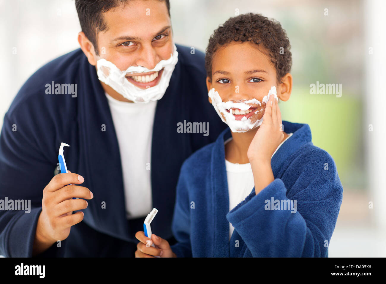 glücklich Sohn spielt mit Vaters Rasierschaum zu Hause Stockfoto