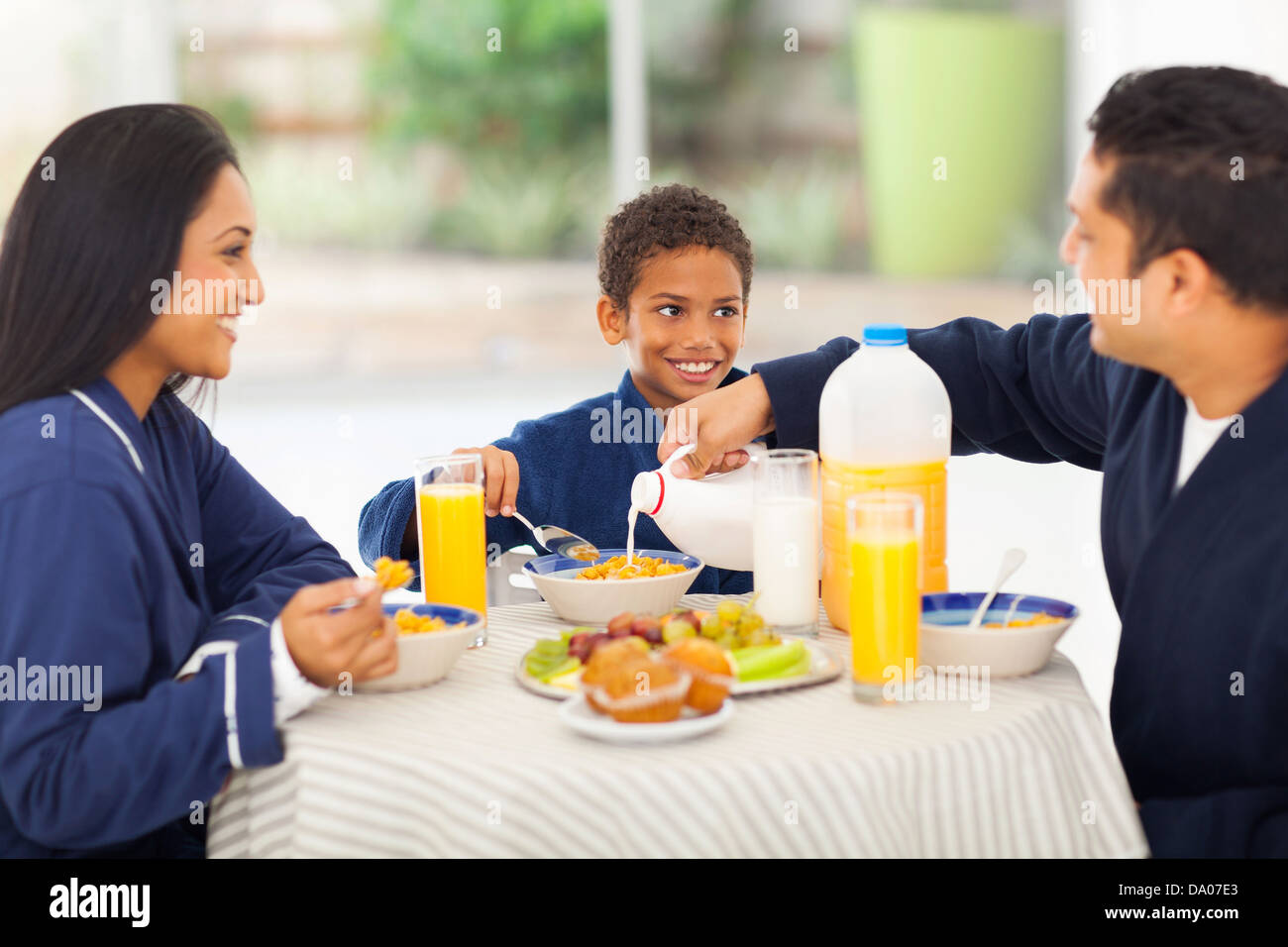 liebender Vater Gießen Milch in seinen Sohn Cornflakes während des Frühstücks Stockfoto
