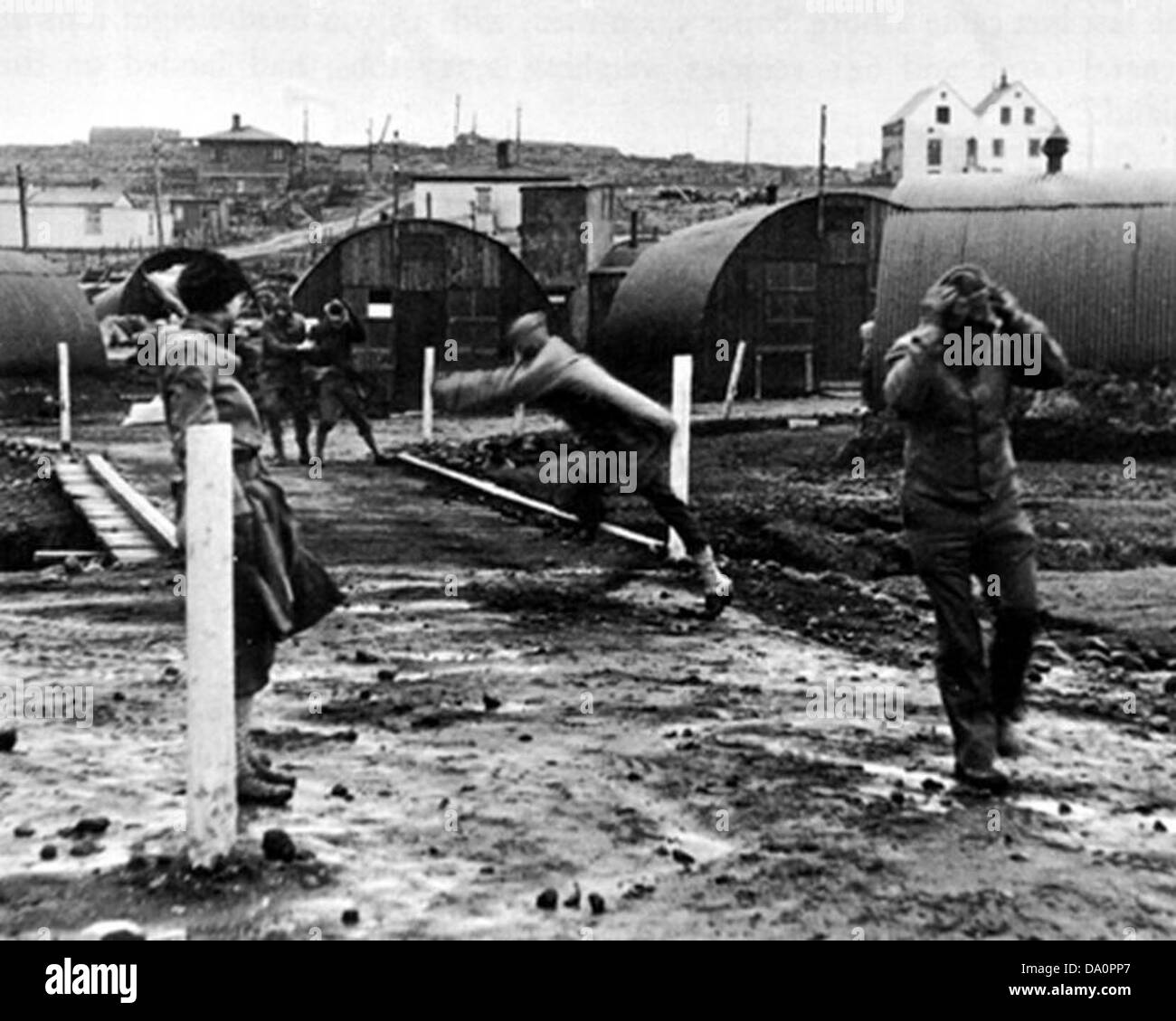 Im IBC-Gebäude von 1942 werden Nissen-Hütten während eines Sturms errichtet. Nisshütten, die als temporäre militärische Bauten genutzt wurden, waren während des Zweiten Weltkriegs essentiell. Der Sturm zeigt die harten Bedingungen, unter denen militärische Infrastruktur entwickelt wurde. Diese Hütten wurden für Kasernen, Lager und operative Zwecke genutzt, um dem Militär während des Krieges wichtige Unterstützung zu bieten. Stockfoto