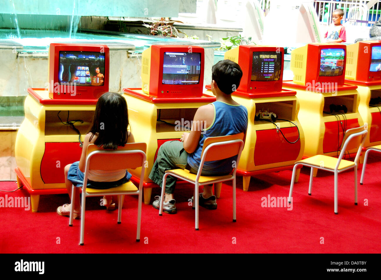 Kinder spielen Computer Spiele Keime ein Spielhaus in einem Einkaufszentrum Stockfoto