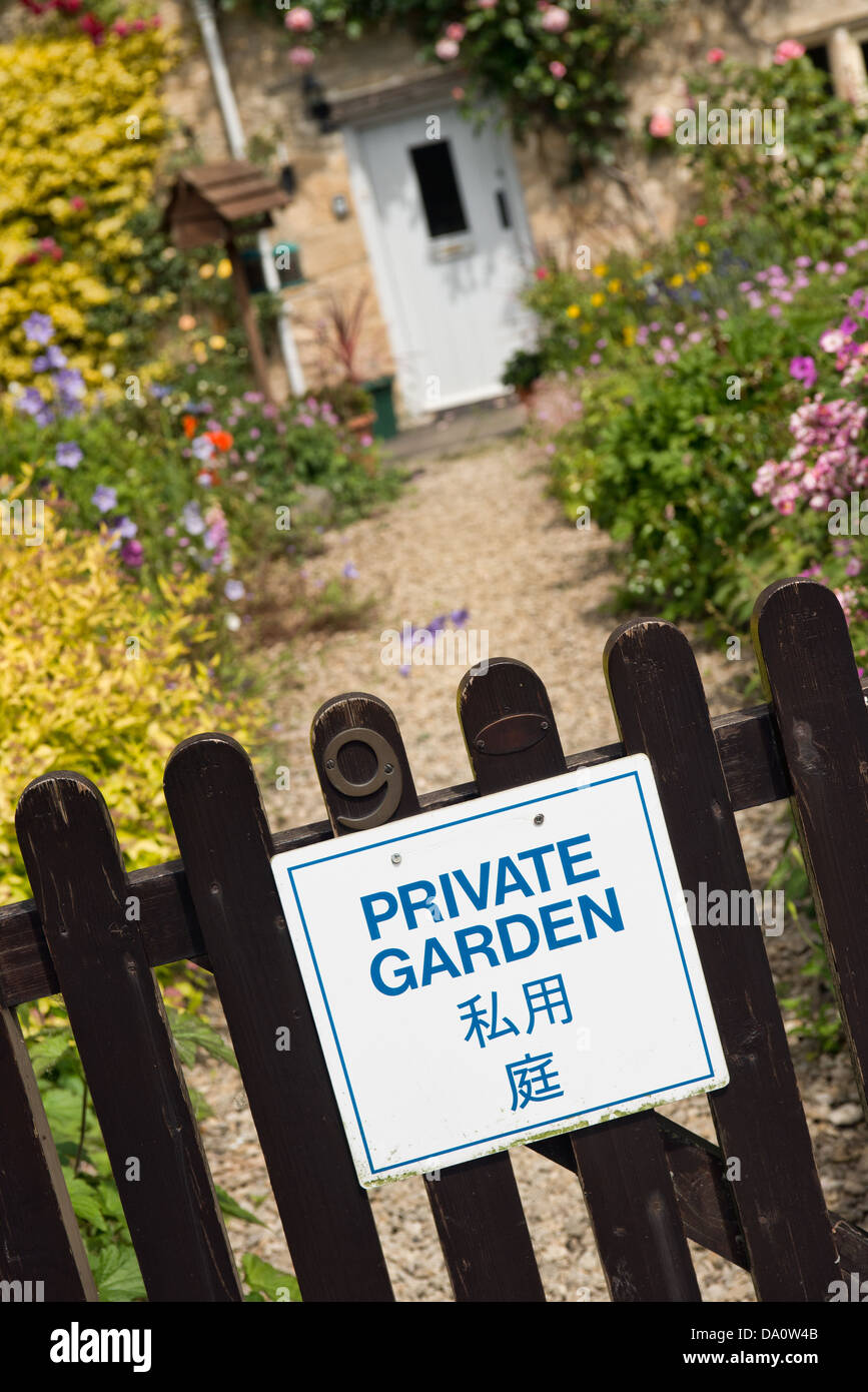 Ein Schild deklarieren "Privatgarten" in Englisch und Japanisch auf dem Tor von einem hübschen Häuschen in Bibury, Gloucestershire, UK Stockfoto