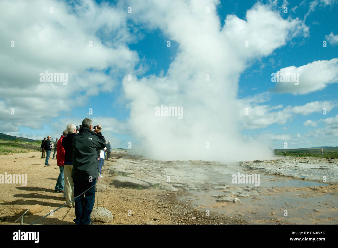 Kameras bereit, Touristen warten, wie ein Dampfstoß die Eruption der wichtigsten Geysir zu Geysir kündigt Stockfoto