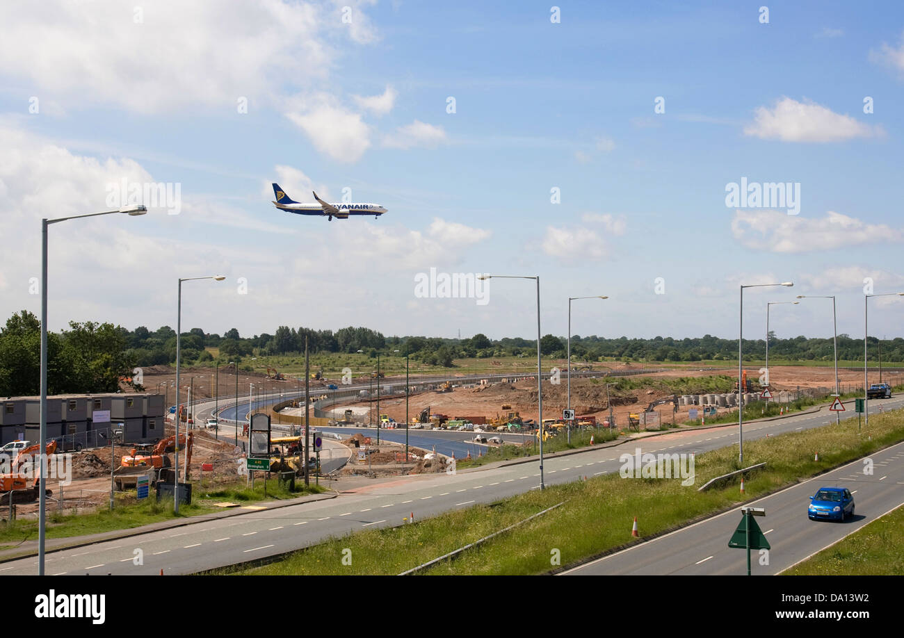 Flugzeug landen herein fliegt über die Baustelle der Landebahn-Verlängerung am Flughafen Birmingham, Juni 2013. Stockfoto