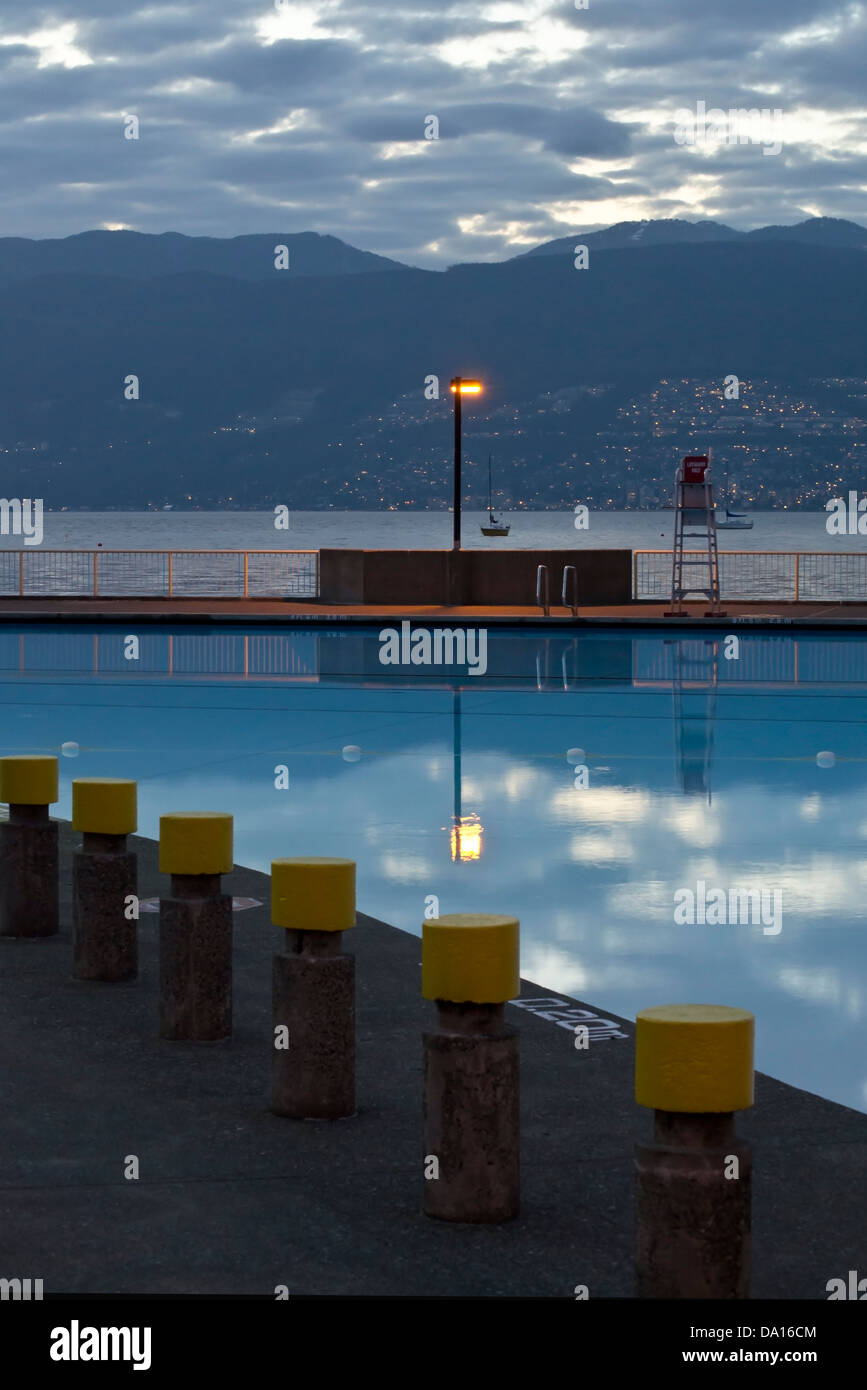 Reflexion in Kitsilano Schwimmbad am Abend, mit False Creek und die North Shore Mountains von Vancouver hinter. Stockfoto