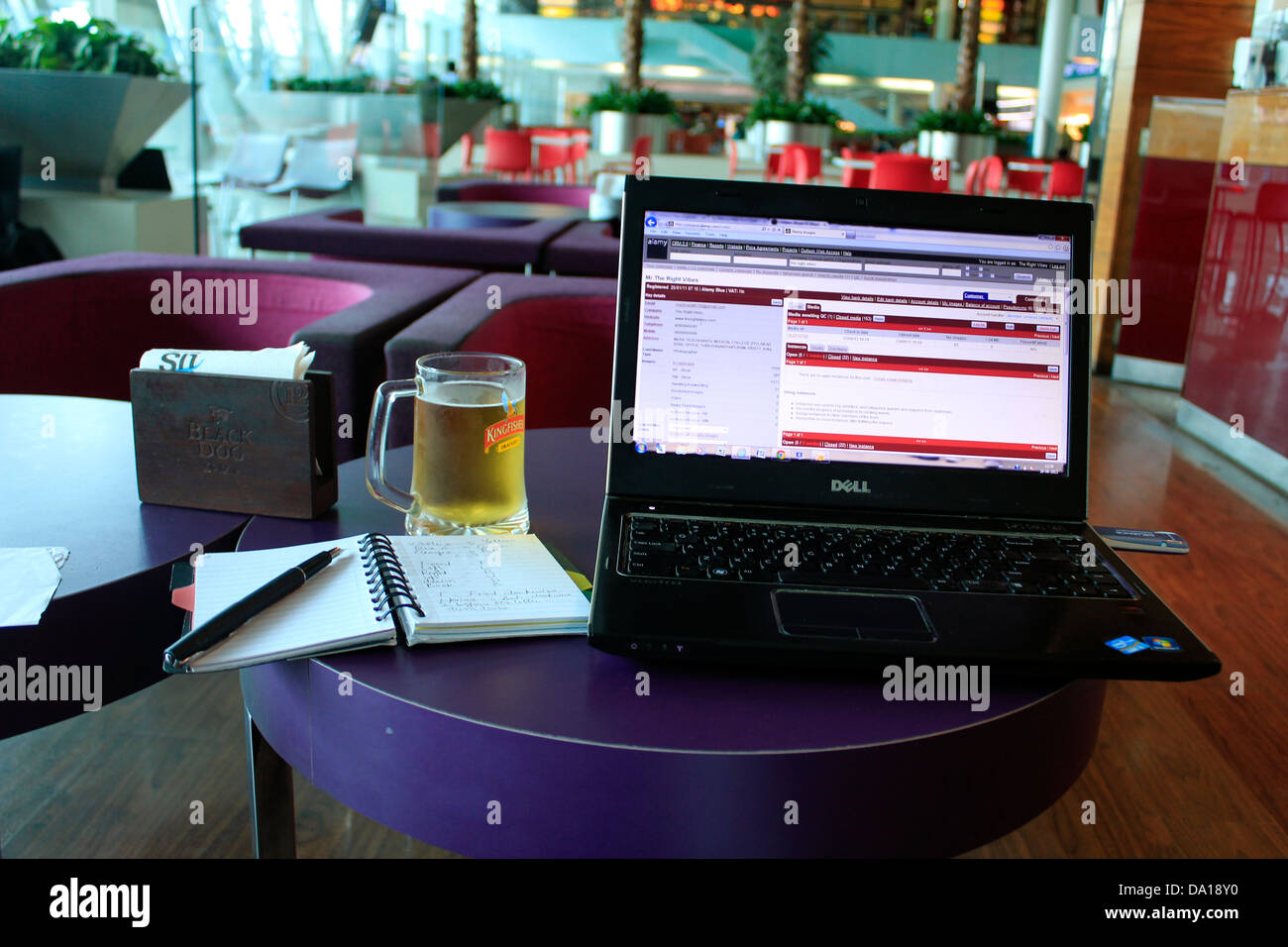 Laptop, Becher Bier und Notizblock Stockfoto