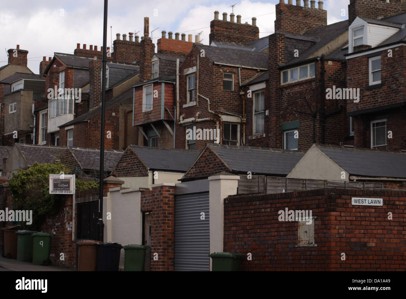 Eine hintere Gasse in Sunderland, England. Hinteren Teil einer Straße von mehrgeschossigen Reihenhäuser beherbergt. Wheelie-Kästen sind für die Sammlung. Stockfoto