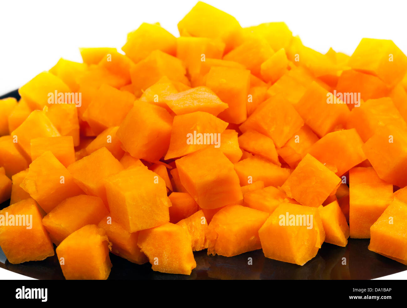 Kleinen Hügel von orange Kürbis Blöcke auf schwarzem Teller Stockfoto