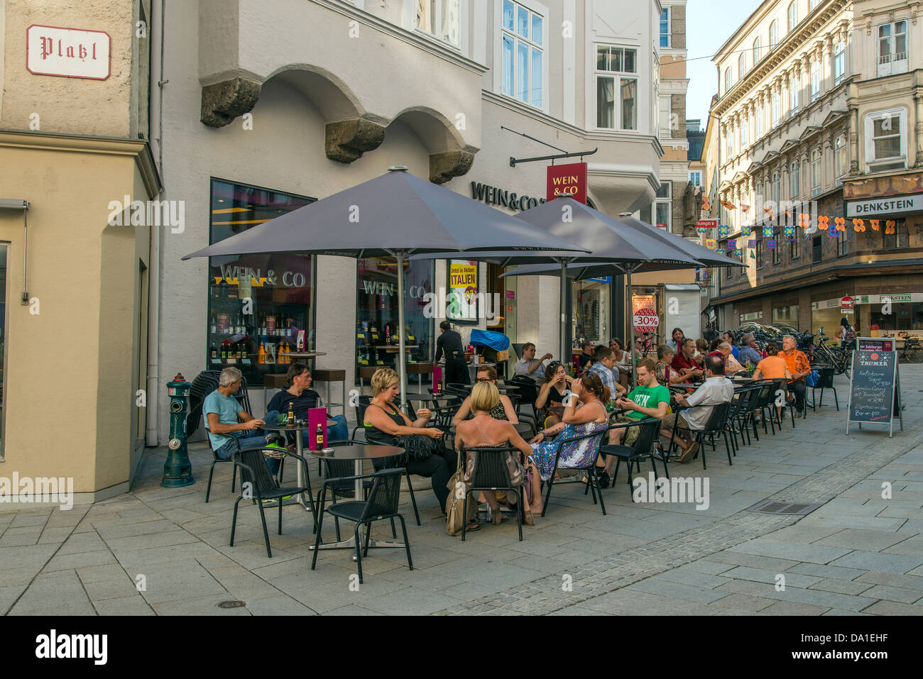 Touristen sitzen in einem Straßencafé in der Linzer Gasse, Salzburg, Österreich Stockfoto