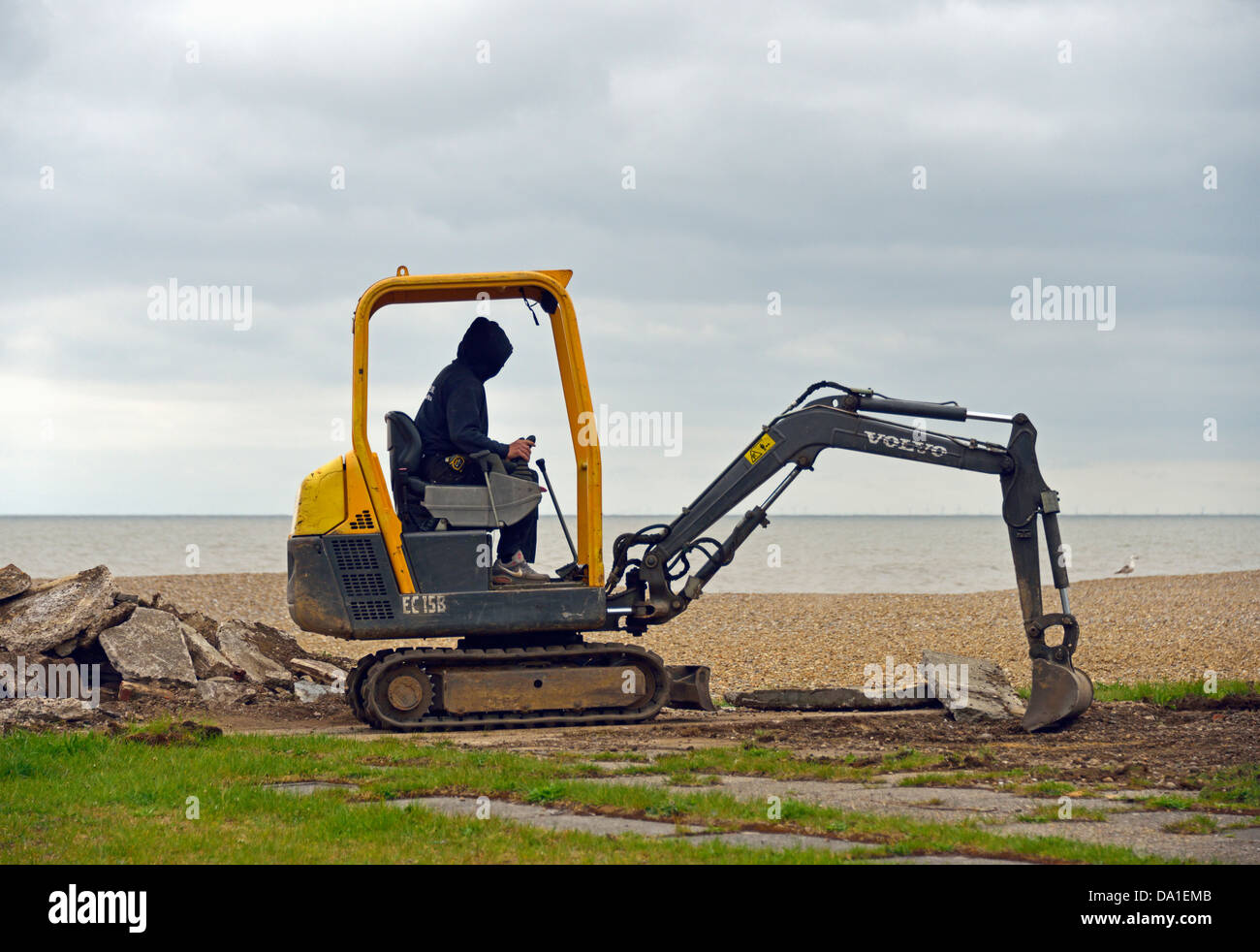 Volvo EC 15 b Minibagger arbeiten am Strand. Aldeburgh, Suffolk, England, Vereinigtes Königreich, Europa. Stockfoto