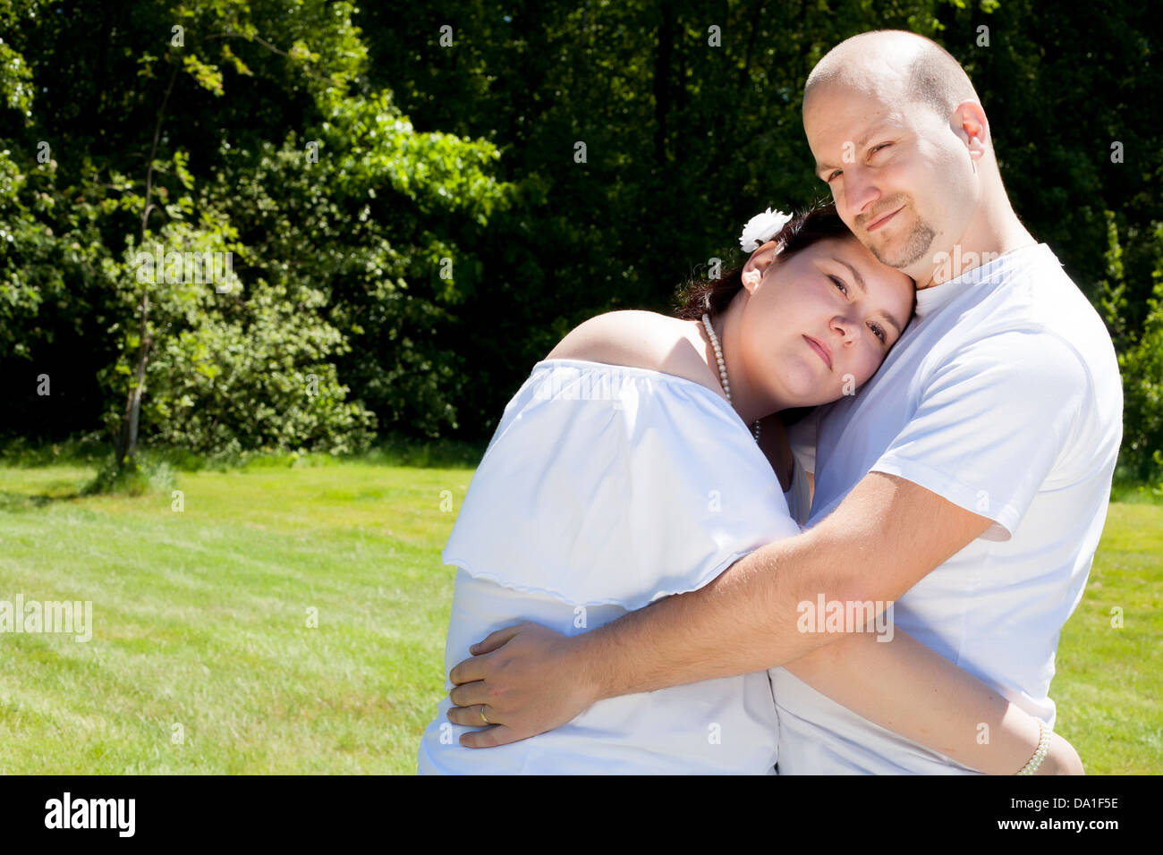 Glückliches junges Paar gekleidet weiß in der Natur Stockfoto