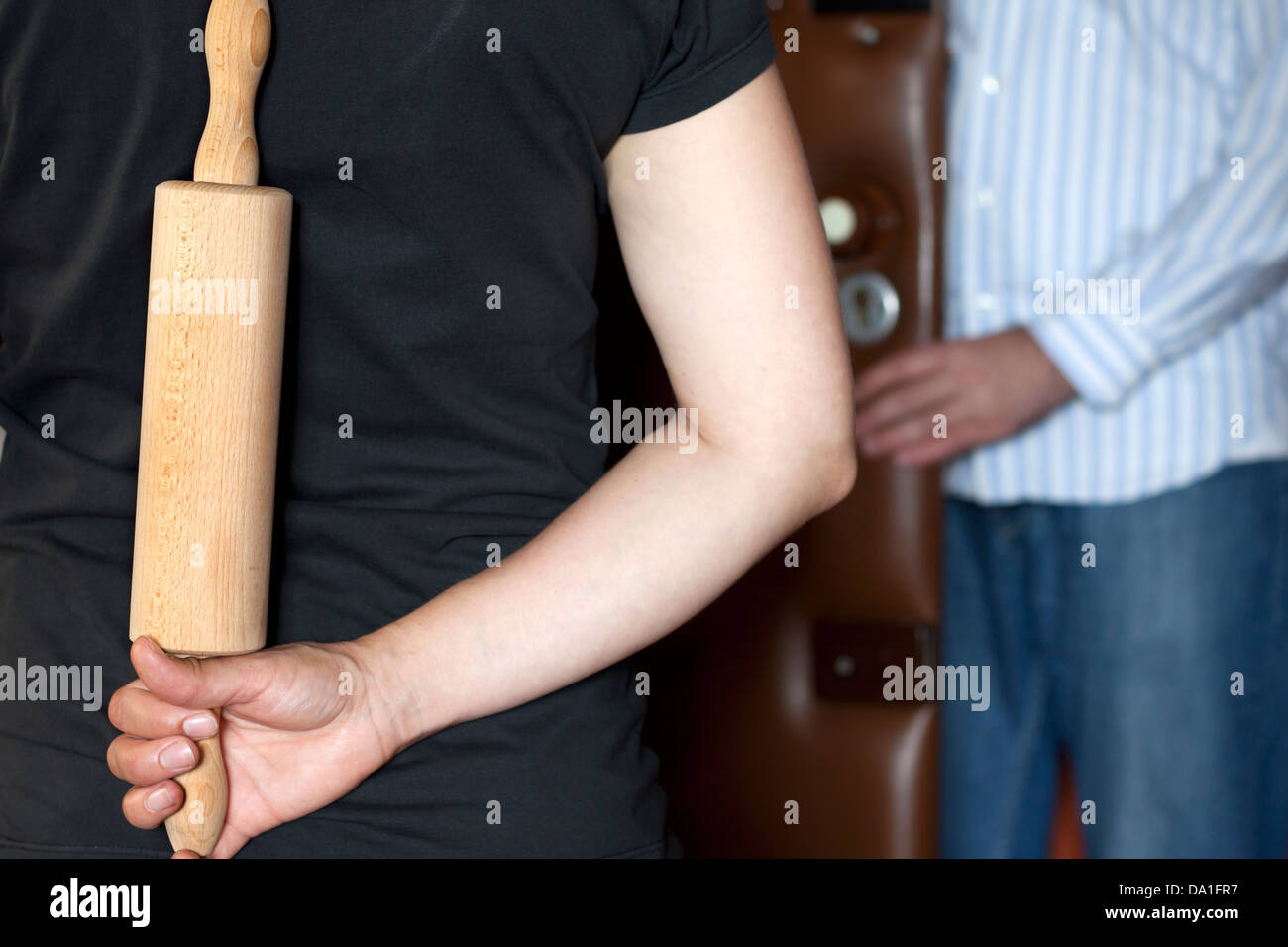 Böse Frau mit Nudelholz betrunken Mann warten Stockfoto