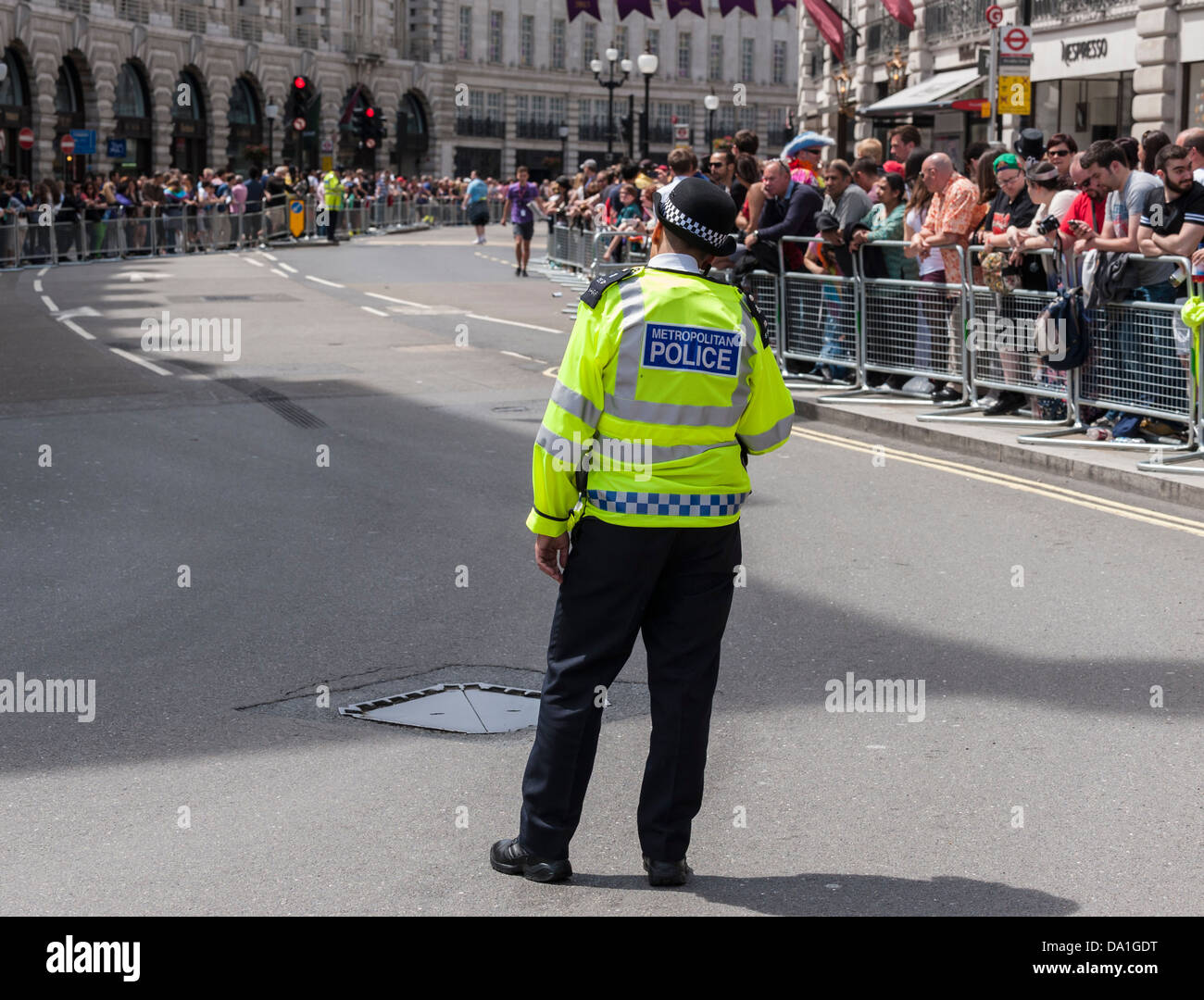 Ein Polizei Polizist steht in der Mitte einer Straße warten auf die London Pride Parade zu beginnen. Stockfoto