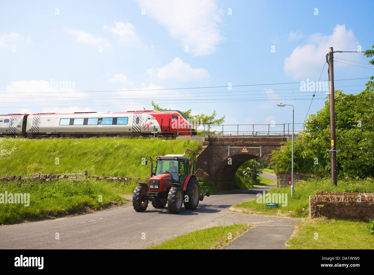 Klasse 390 Jungfrau Pendolino-Zug an der Plumpton auf der West Coast Main Line Railway mit Traktor durch den Tunnel unten kommen. Stockfoto