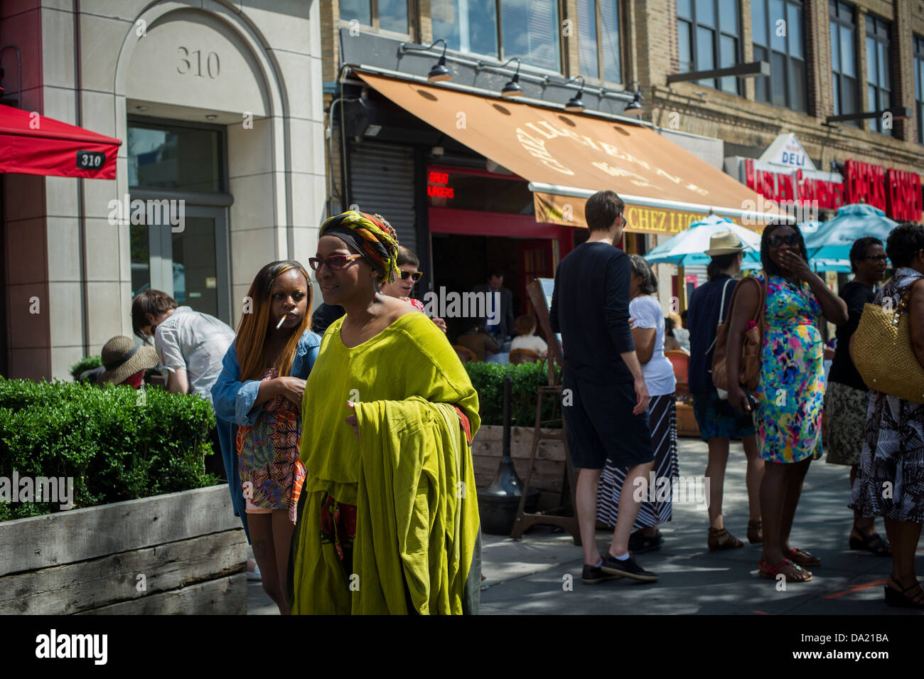 Gönner und Passanten gesehen an Restaurant Row an der Lenox Avenue im Stadtteil Harlem in New York Stockfoto
