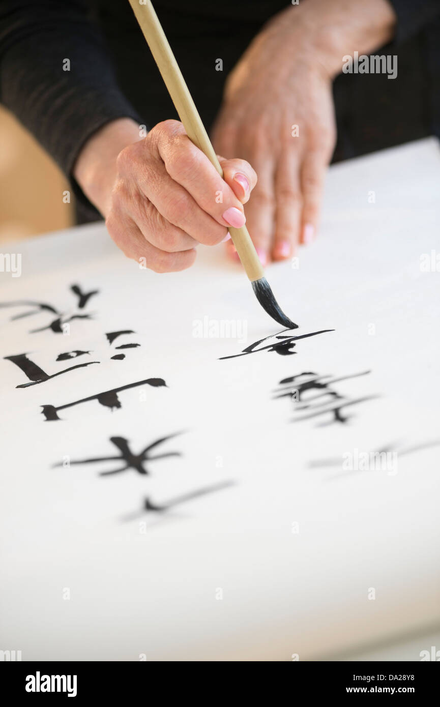 Weibliche Hände und japanische Kalligraphie Stockfoto