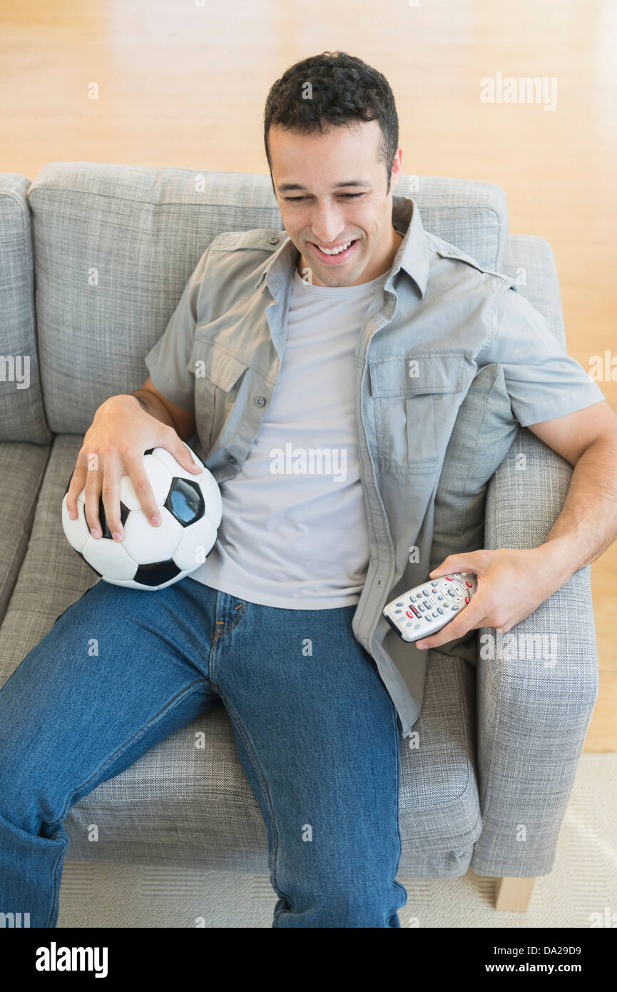 Junger Mann beobachten Fußballspiel im Fernsehen Stockfoto