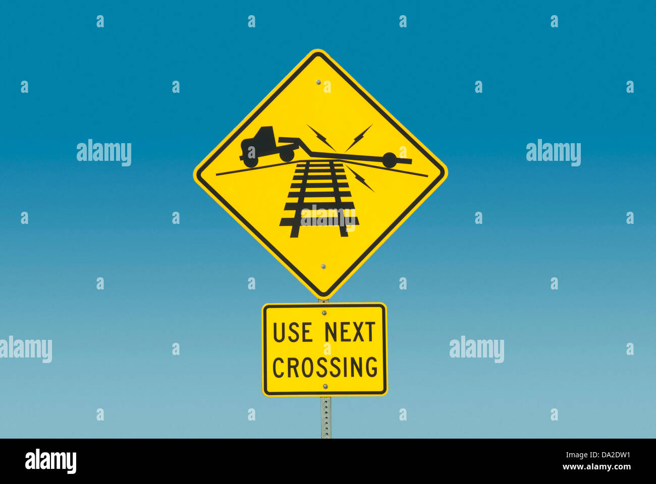 Gelbes Straßenschild Darstellung LKW am Bahnübergang Stockfoto